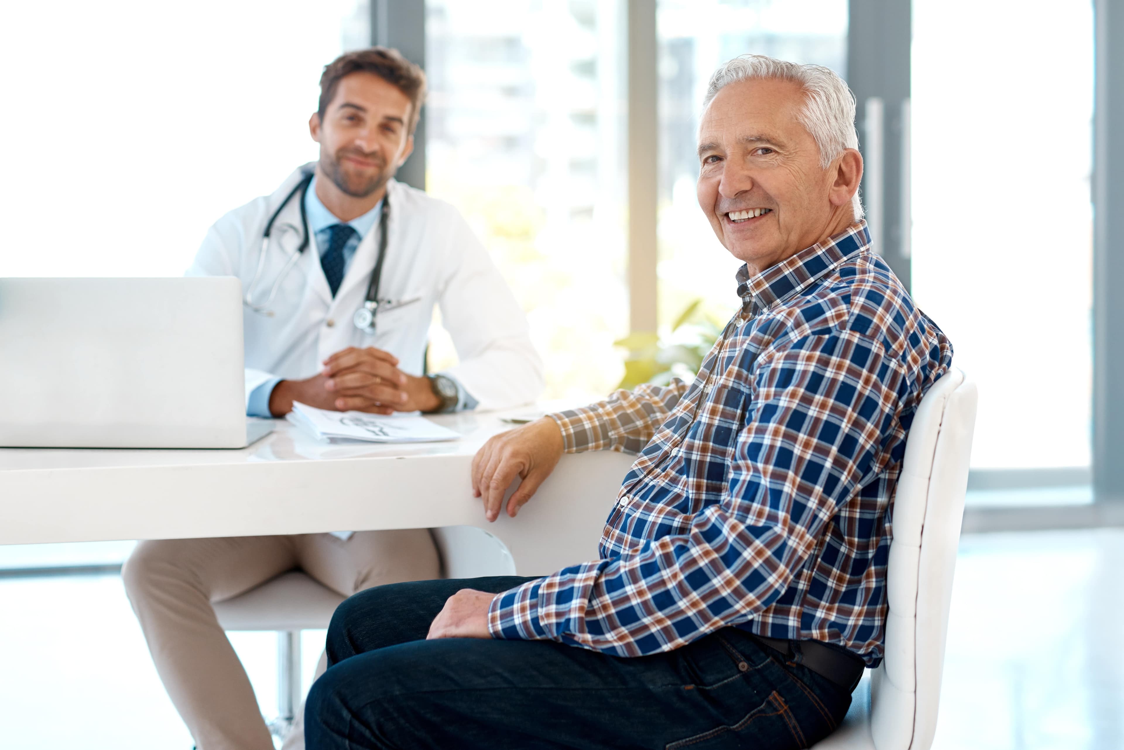 Ein Arzt berät einen älteren männlichen Patienten wegen erektiler Dysfunktion.