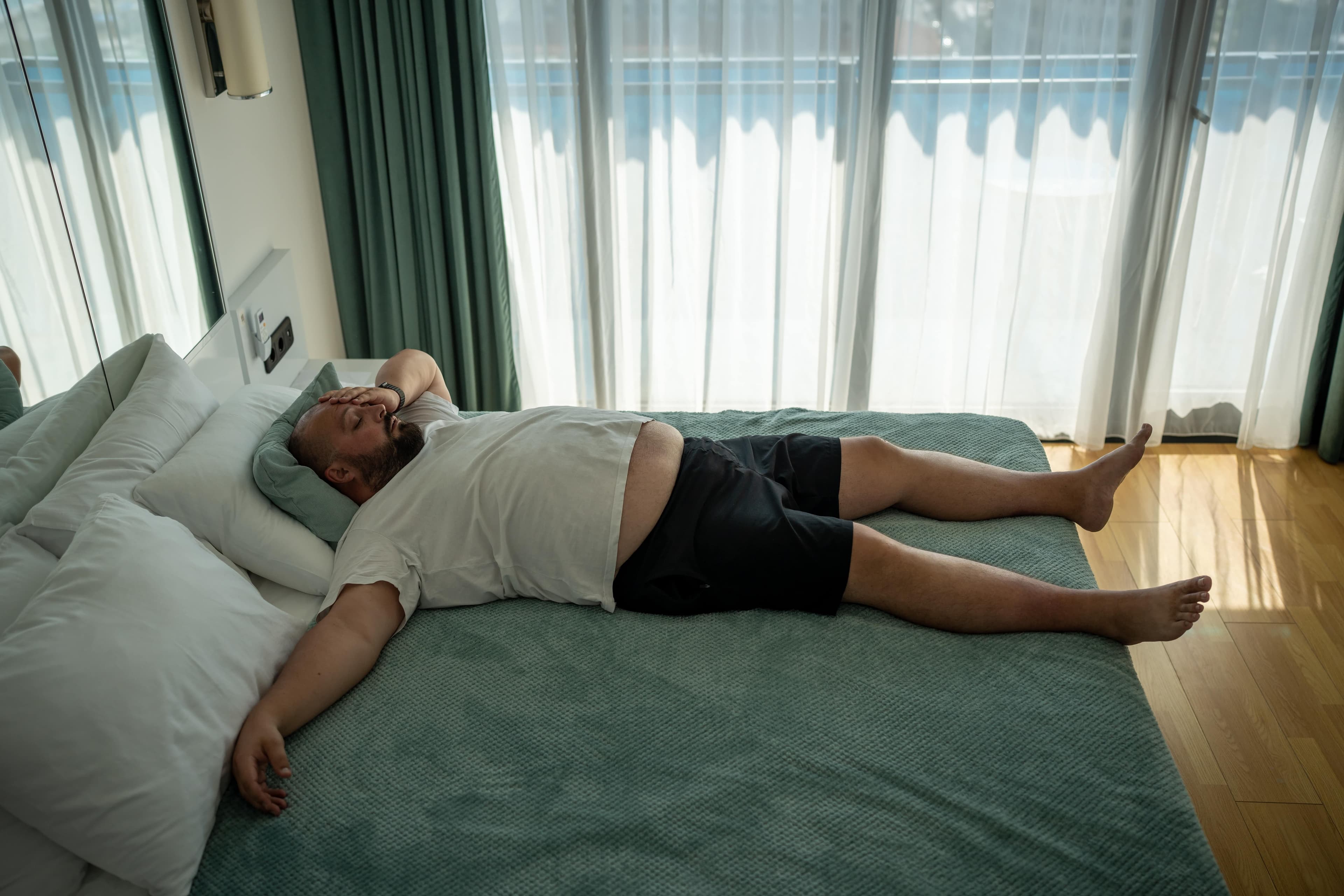 Ein übergewichtiger Mann, der in seinem Bett schläft.